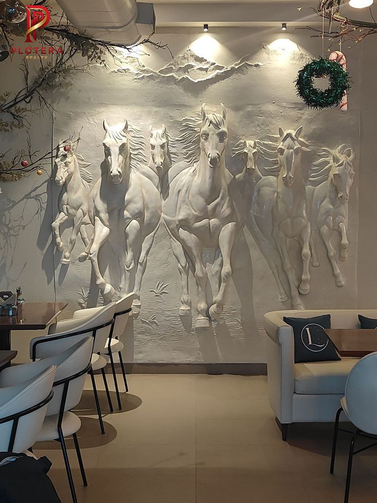 An impressive 3d wallpaper mural in a dining area featuring a group of wild horses running forward in high-relief. The sculptural white design creates a powerful sense of motion and texture, illuminated by overhead spotlights to highlight the detailed forms of the galloping horses.