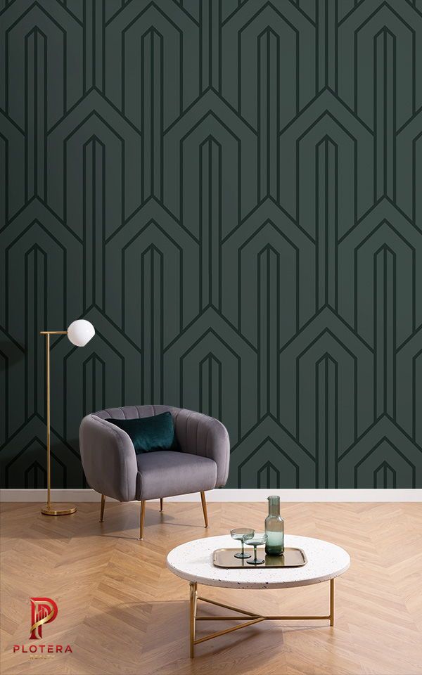 An elegant lounge area highlighted by a deep forest green geometrical wallpaper featuring a bold, architectural Art Deco-inspired linework pattern. The sleek, dark wall provides a moody and refined atmosphere that perfectly complements a velvet accent chair and gold floor lamp.